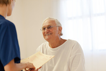 Nurse talking with older patient in hospital