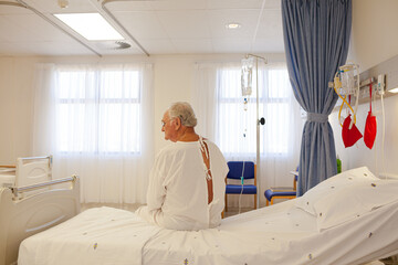 Older patient wearing gown in hospital room