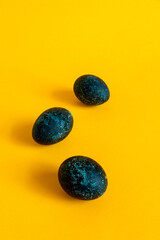 Three blue eggs on a yellow background. Feast of Bright Easter. High quality photo