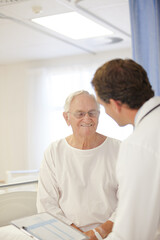 Doctor talking to older patient in hospital