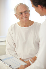 Doctor talking to older patient in hospital