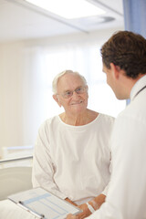 Doctor talking to older patient in hospital