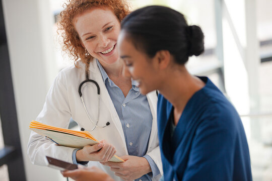 Doctor And Nurse Talking In Hospital Hallway