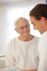 Doctor talking to older patient in hospital