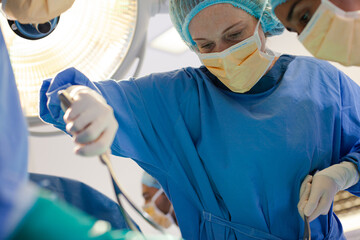 Surgeons bent over patient on operating table