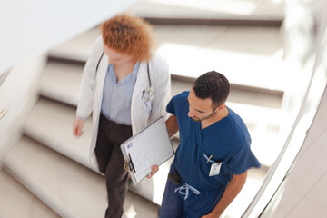 Doctor and nurse walking on hospital steps