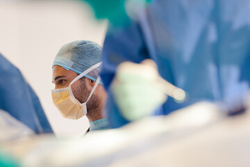 Surgeons bent over patient on operating table