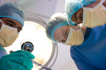 Surgeons bent over patient on operating table