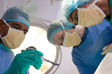 Surgeons bent over patient on operating table