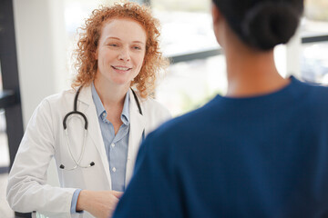 Doctor and nurse talking in hospital hallway