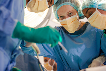 Surgeons bent over patient on operating table