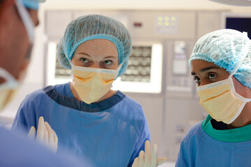 Fototapeta na wymiar Surgeons bent over patient on operating table