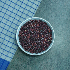 top view of ceramic bowl with black beans on a dark marble surface
