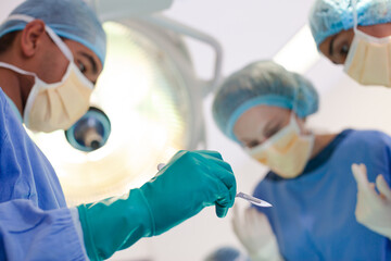 Surgeons bent over patient on operating table