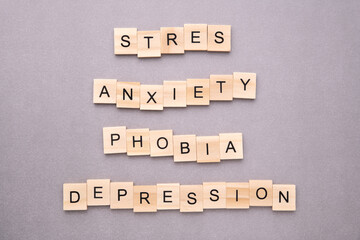 Words stress, anxiety, phobia and depression on wooden blocks on grey background. Mental health problems concept