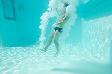 Man posing underwater in swimming pool