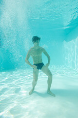 Man posing underwater in swimming pool
