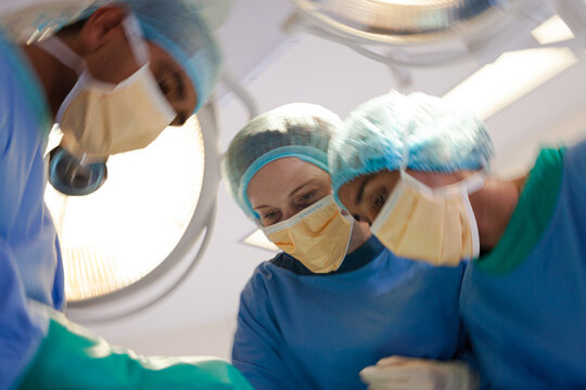 Surgeons bent over patient on operating table