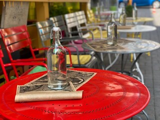 Table setting in restaurant. Colorful red yellow  tables and chairs in a French cafe.  Cozy French street cafe.