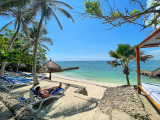 Plakat Man relaxing in a tropical beach with turquoise water in Baru, Islas del Rosario, Cartagena de Indias, Colombia.