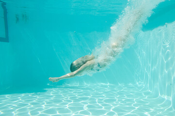 Woman swimming underwater in pool