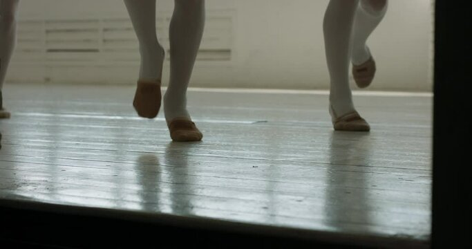 Close up shot of legs of kids running out of hall. Girls wearing pointe shoes have their dance or ballet class over 4k footage