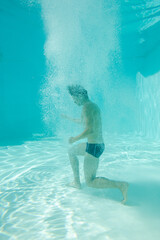 Man posing underwater in swimming pool