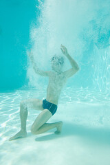 Man posing underwater in swimming pool