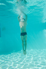 Man posing underwater in swimming pool