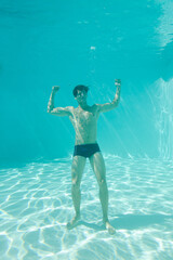 Man posing underwater in swimming pool