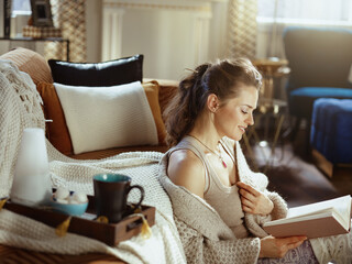 happy modern woman reading in modern house in sunny autumn day