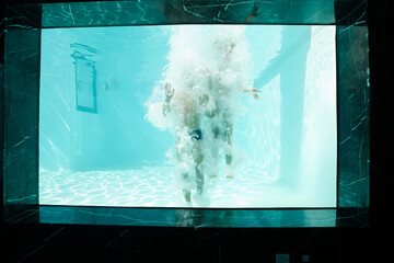 Couple posing underwater in swimming pool