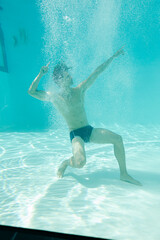 Man posing underwater in swimming pool