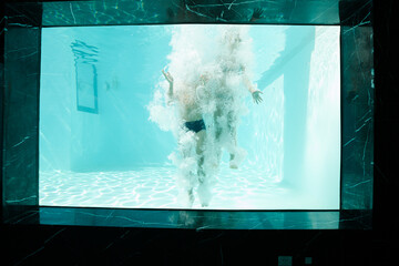 Couple posing underwater in swimming pool