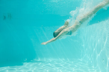 Woman swimming underwater in pool