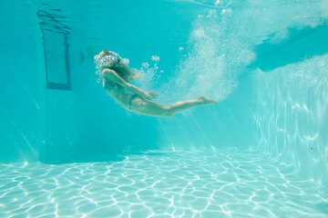 Woman swimming underwater in pool