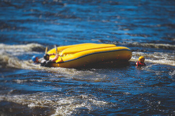 Boat is turned upside down during rafting extreme water sports with man drowning, concept of fail...