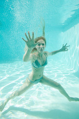 Obraz na płótnie Canvas Woman posing underwater in pool