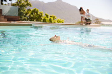 Woman floating in swimming pool