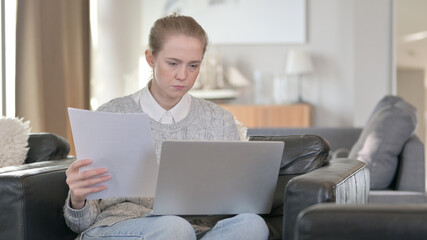 Woman working on Laptop with Documents at Home
