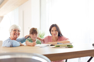 Mother  and grandmother helping girl with homework