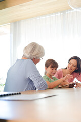 Three generations of women using tablet computer