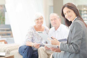 Obraz premium Financial advisor smiling with couple on sofa