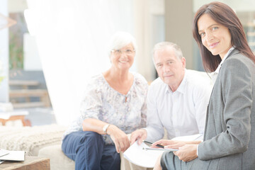Financial advisor smiling with couple on sofa
