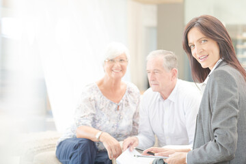 Financial advisor smiling with couple on sofa
