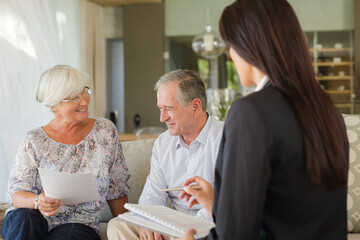 Financial advisor talking to couple on sofa