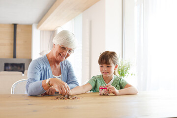 Older woman and granddaughter counting pennies