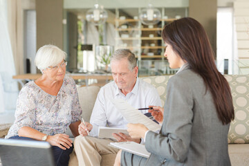 Financial advisor talking to couple on sofa