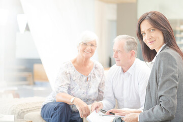 Obraz premium Financial advisor smiling with couple on sofa