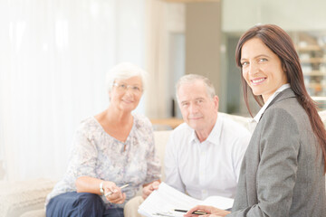 Financial advisor smiling with couple on sofa